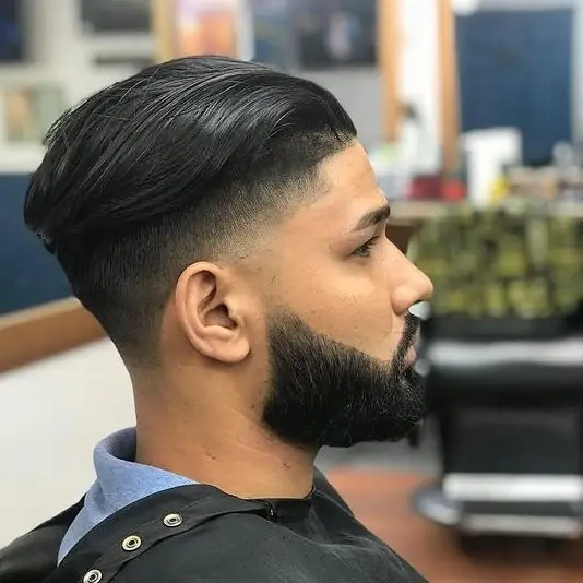 Slick-back with a fade and a thick, sharp beard