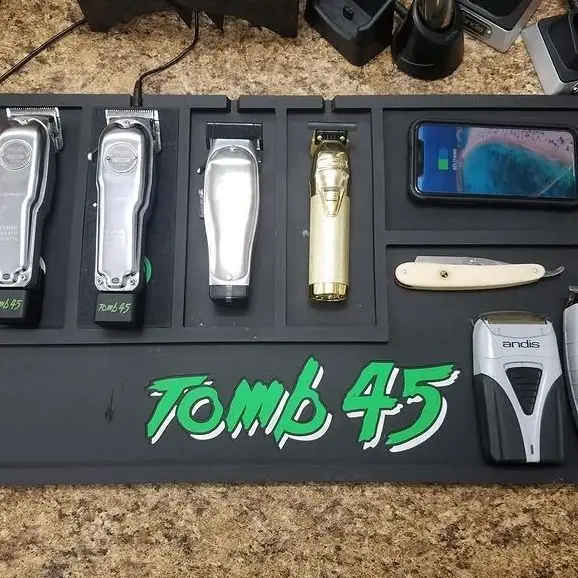 Clippers, trimmers and a straight razor lined up in the charging tray